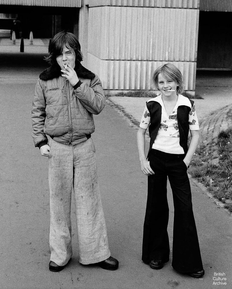 Black and white photograph of two British boys standing on a street in the 1970s, reflecting working-class youth culture and everyday life in Britain.