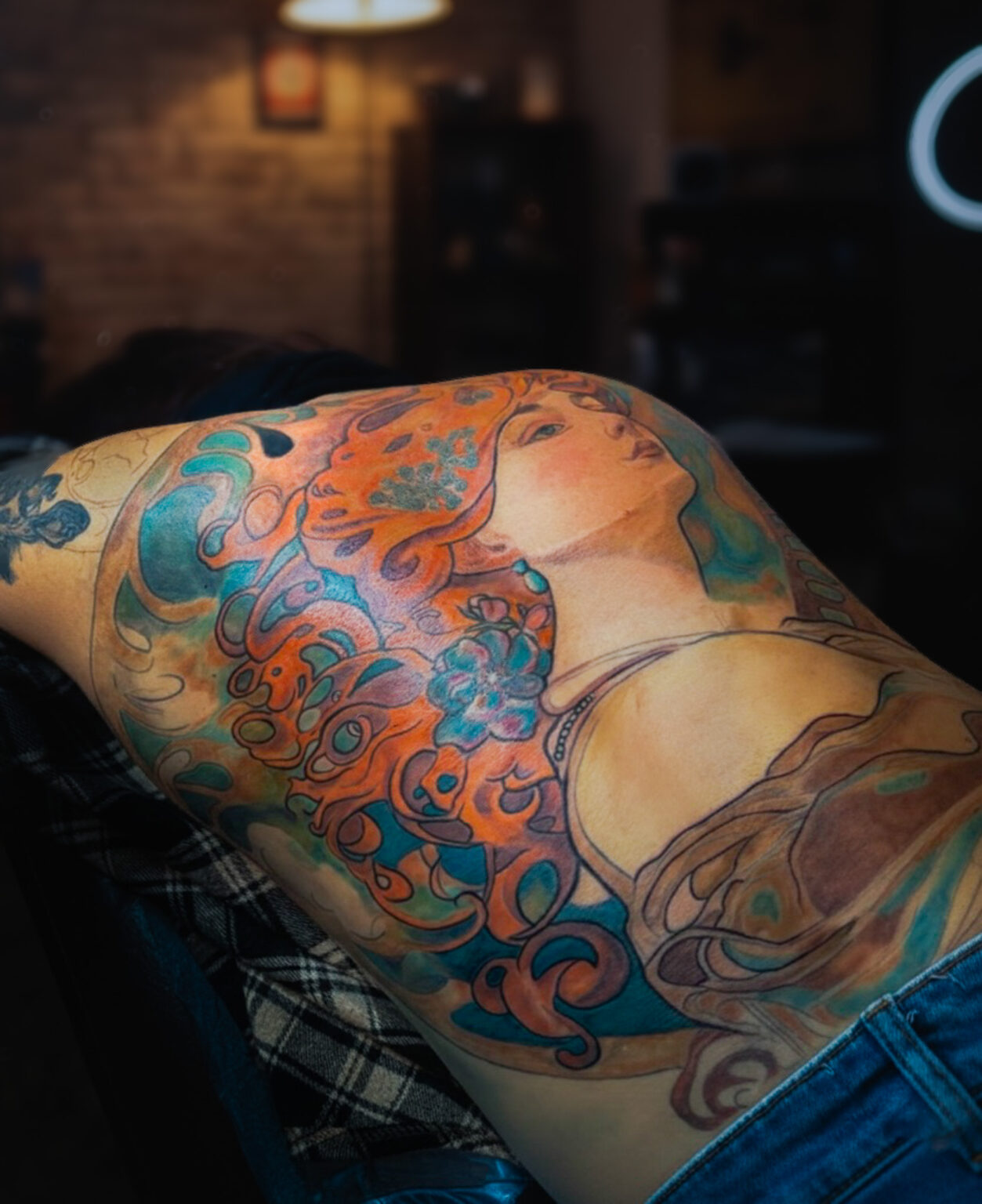 Art Nouveau tattoo portrait on the thigh featuring flowing ornamental lines and soft colour work, tattooed by Tamara Chaudesaigues, tattoo artist based in Avignon and working between France and London.