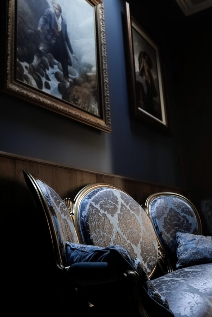 Period Napoleon damask sofa and antique paintings in gilded frames at Gourmet & Glouton restaurant, Chaudes-Aigues