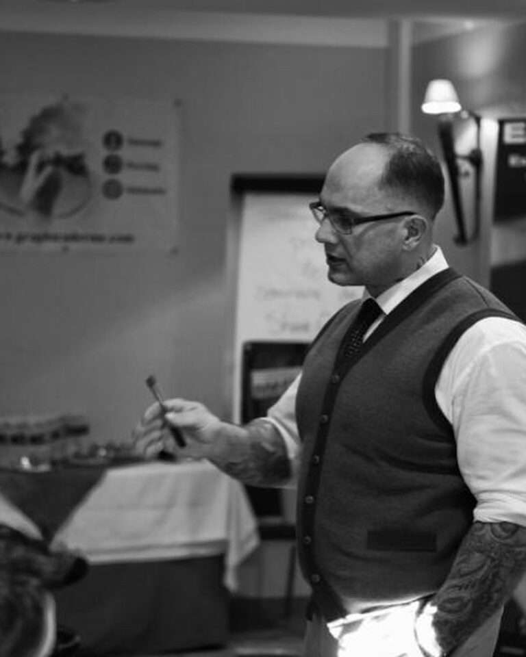 Black and white photograph of tattoo artist Stéphane Chaudesaigues working in his studio, illustrating precision, transmission and professional tattoo practice.
