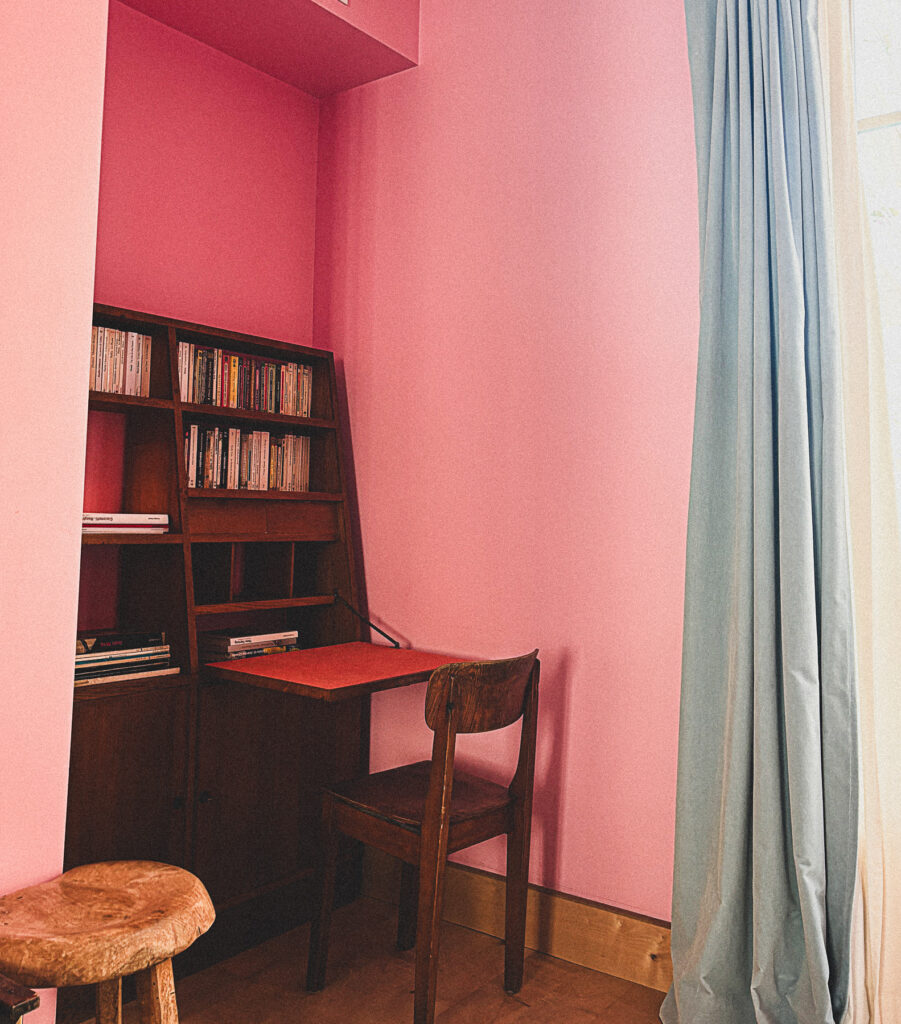 Bureau en bois et étagères dans une chambre rose de l’Hôtel Amour à Nice