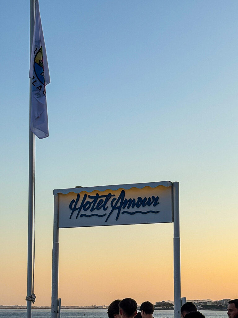Panneau Hôtel Amour sur la plage à Nice au coucher du soleil