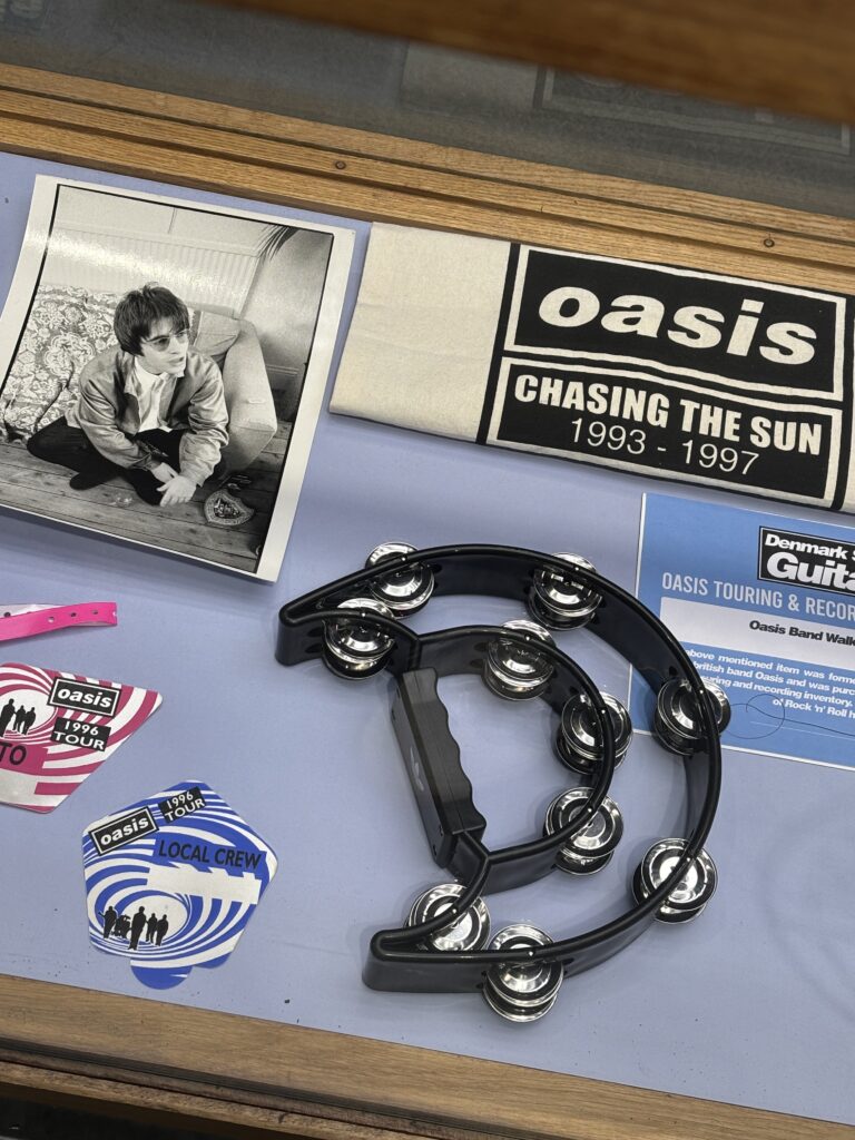 Oasis Chasing the Sun 1993-1997 memorabilia, stickers and tambourine at Adidas London