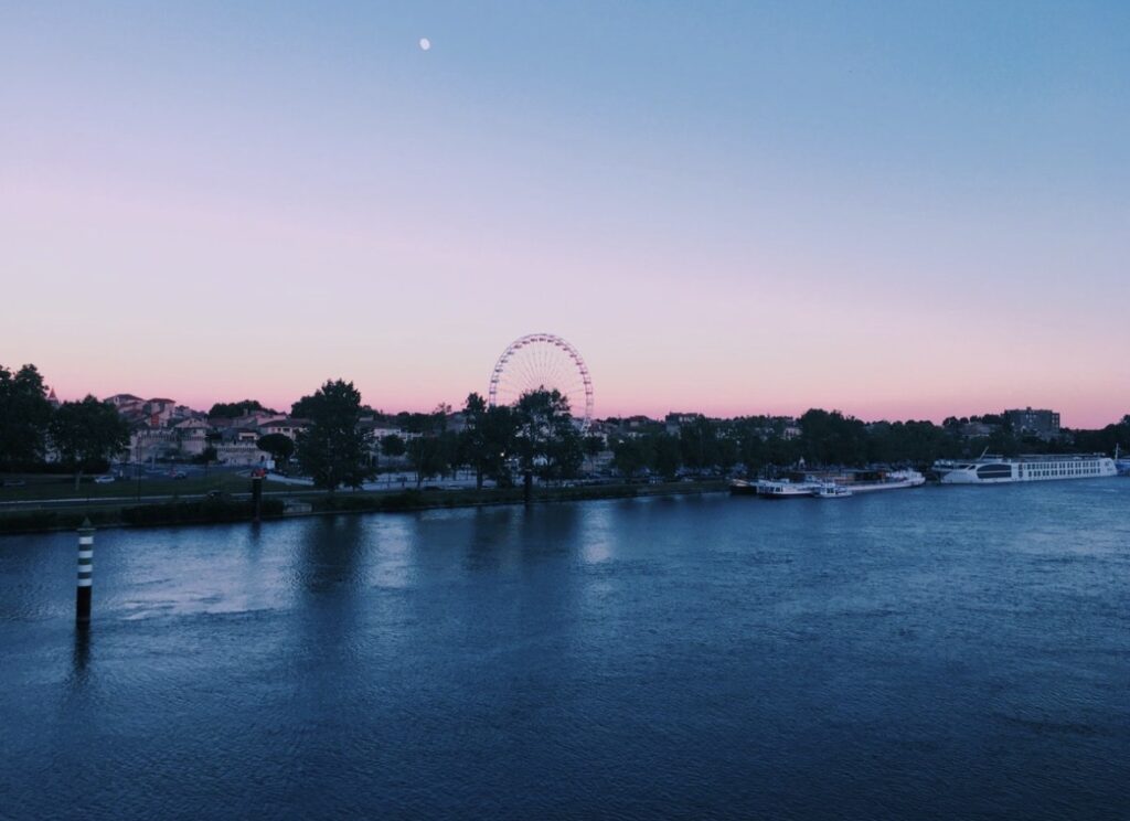 Vue sur le Rhône au coucher du soleil à Avignon avec la grande roue du Festival en arrière-plan