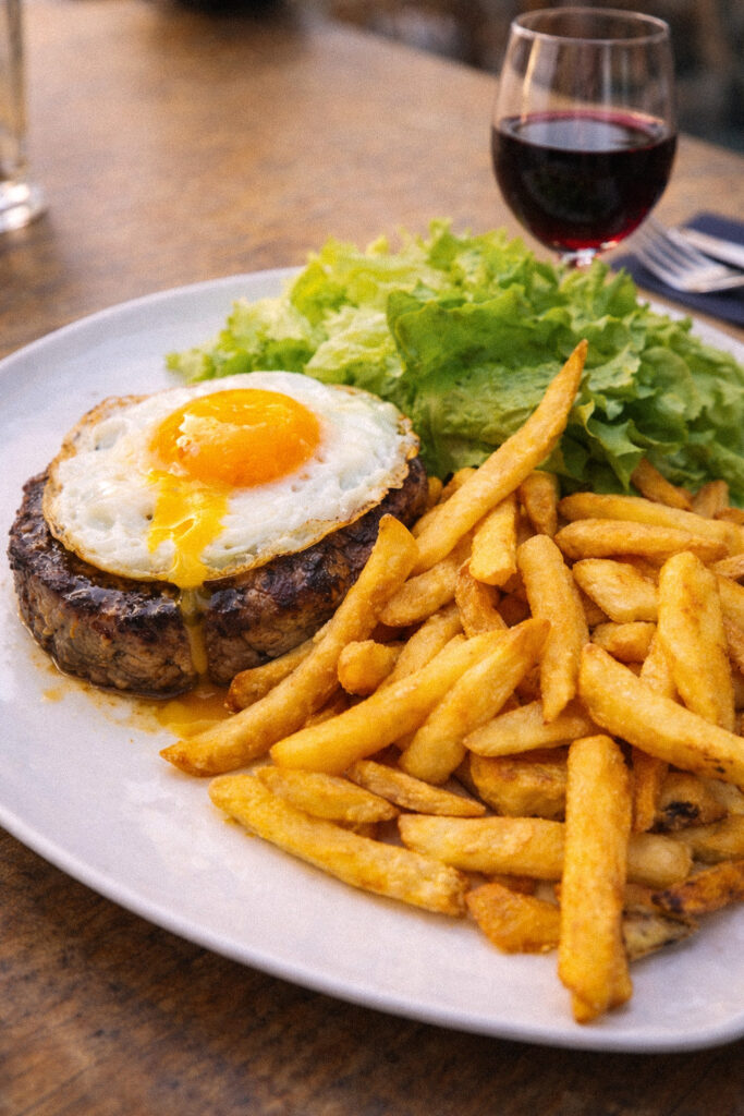 Steak à cheval avec œuf au plat et frites maison au Bar du Change, place du Change Avignon, verre de vin rouge