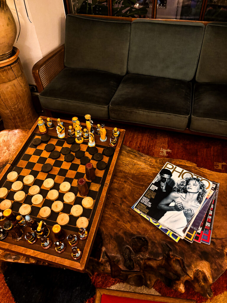 Living room with chess set and green sofa at Hôtel Amour Nice