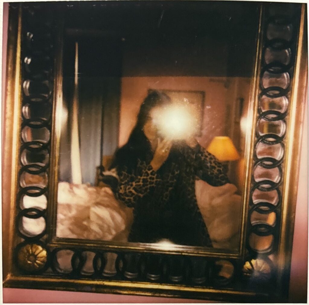 Mirror selfie in the golden sculpted mirror of the pink room at Hôtel Amour Nice, warm bedside light