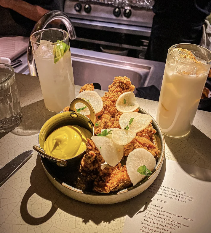 Poulet frit croustillant avec sauce et cocktails au restaurant Kricket Londres