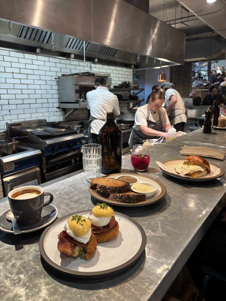 Open kitchen counter at Ozone Shoreditch London, eggs benedict and coffee Caption : Ozone — eggs benedict at the counter, Shoreditch London