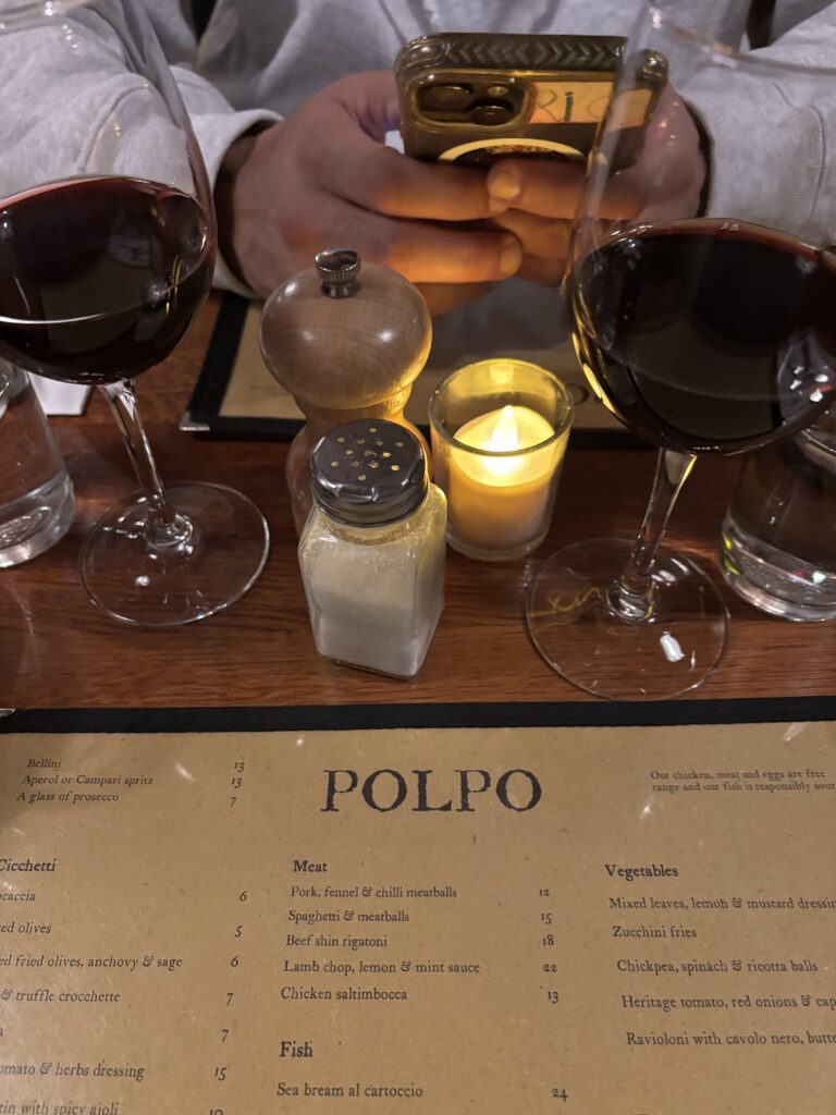 Menu du restaurant Polpo à Soho Londres, verres de vin rouge sur table en bois