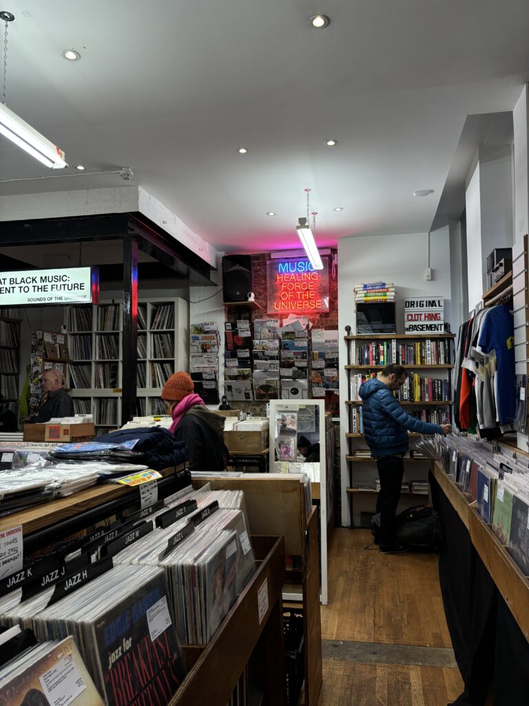 Intérieur de Sounds of the Universe à Soho Londres, bacs de vinyles et néon Music Healing Force
