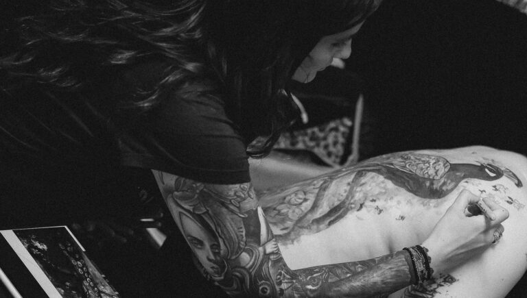 tatoueuse en train de dessiner un tatouage sur le dos à avignon.