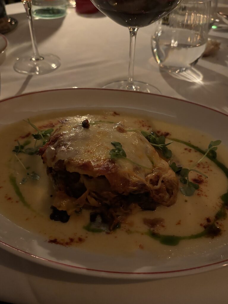 Lasagne gratinée au restaurant The Dover à Mayfair Londres, nappe blanche et vin rouge