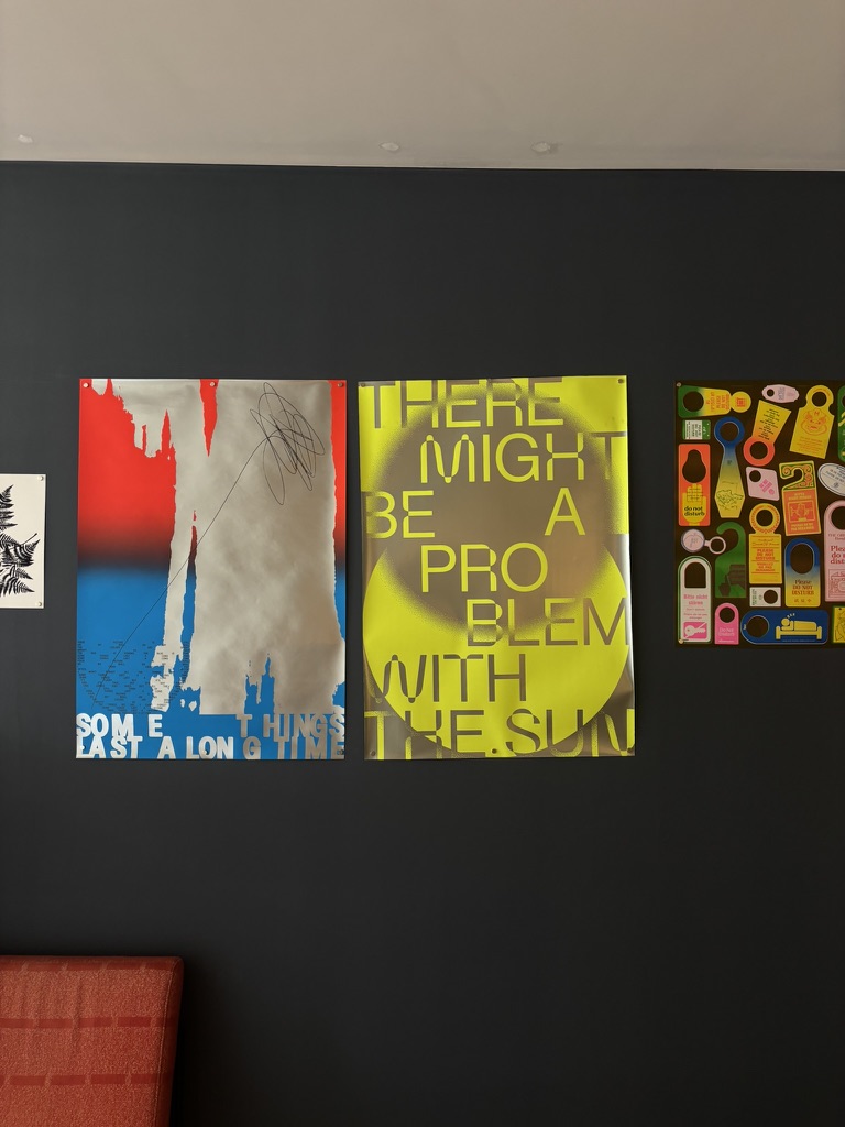Affiches colorées aux typographies graphiques accrochées dans la librairie de LUMA Arles