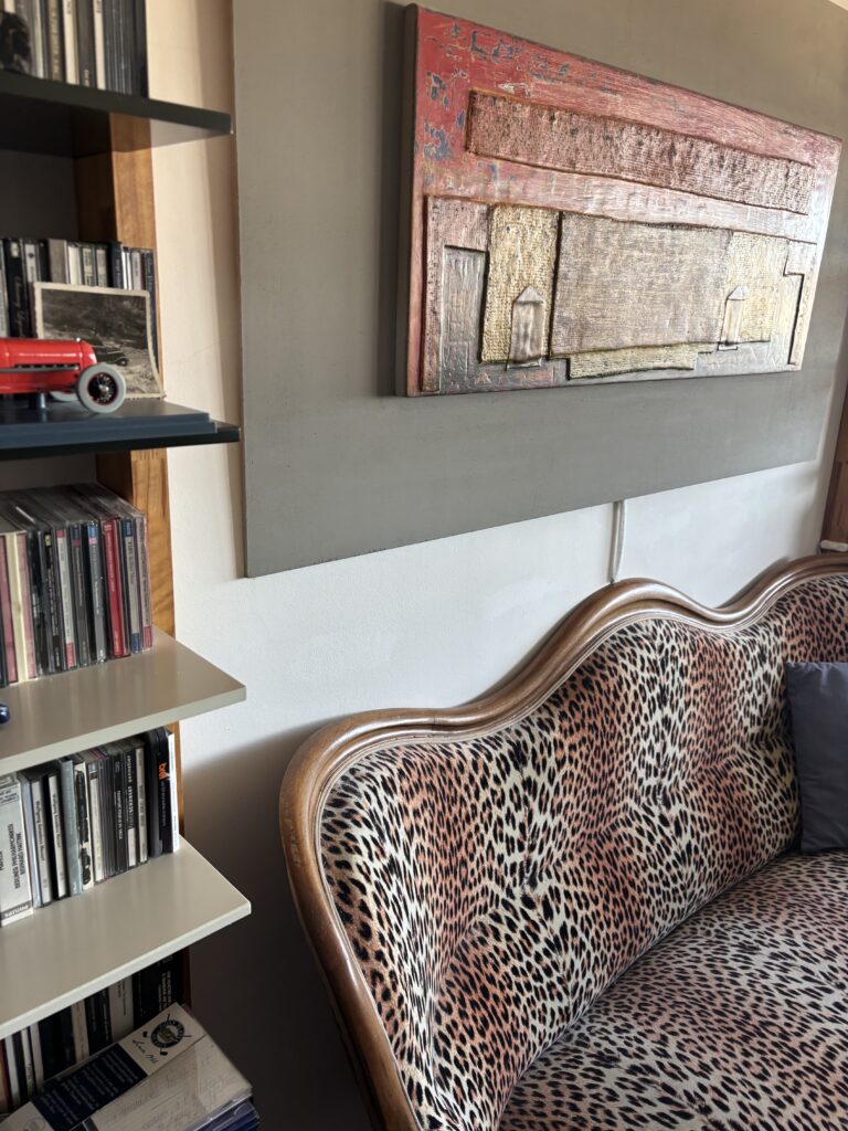 Canapé léopard, œuvre murale et collection de CD dans un appartement habité de la Cité Radieuse