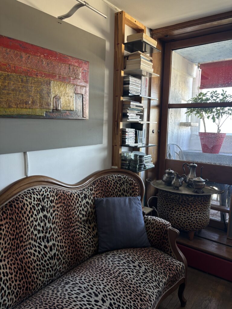Canapé léopard, table avec service à thé, livres et baie vitrée dans un duplex de la Cité Radieuse