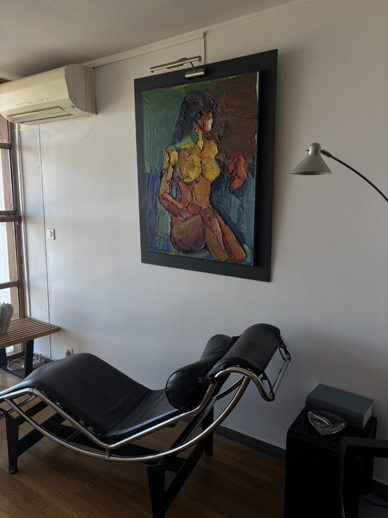 Chaise longue noire en métal chromé sous un tableau coloré dans un duplex de la Cité Radieuse