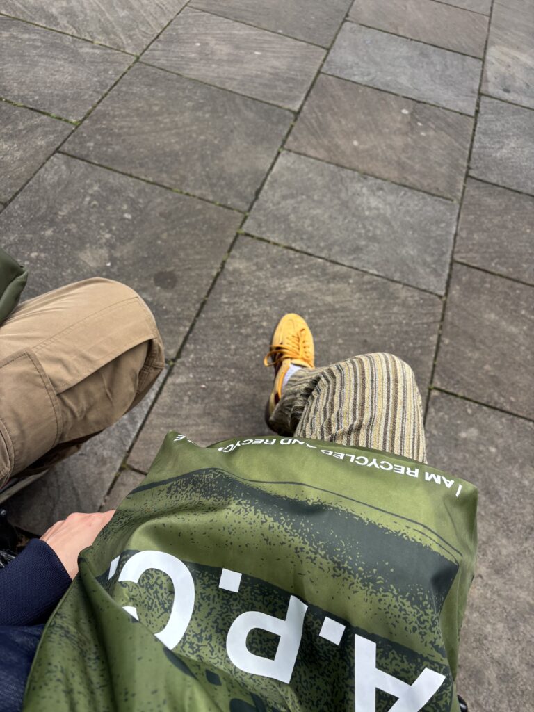 Sac A.P.C. vert posé sur les genoux pendant une pause à Hampstead à Londres