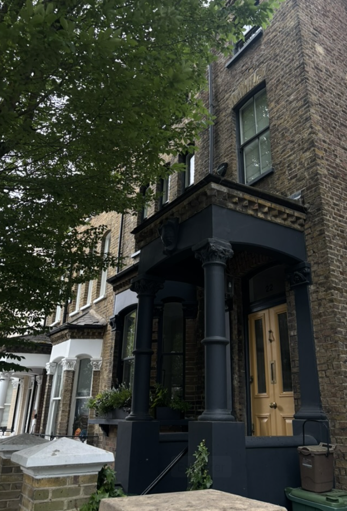 Maison en briques avec porche noir dans une rue résidentielle de Hampstead