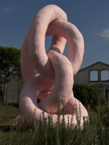 Œuvre rose monumentale entourée de végétation dans le parc de LUMA Arles