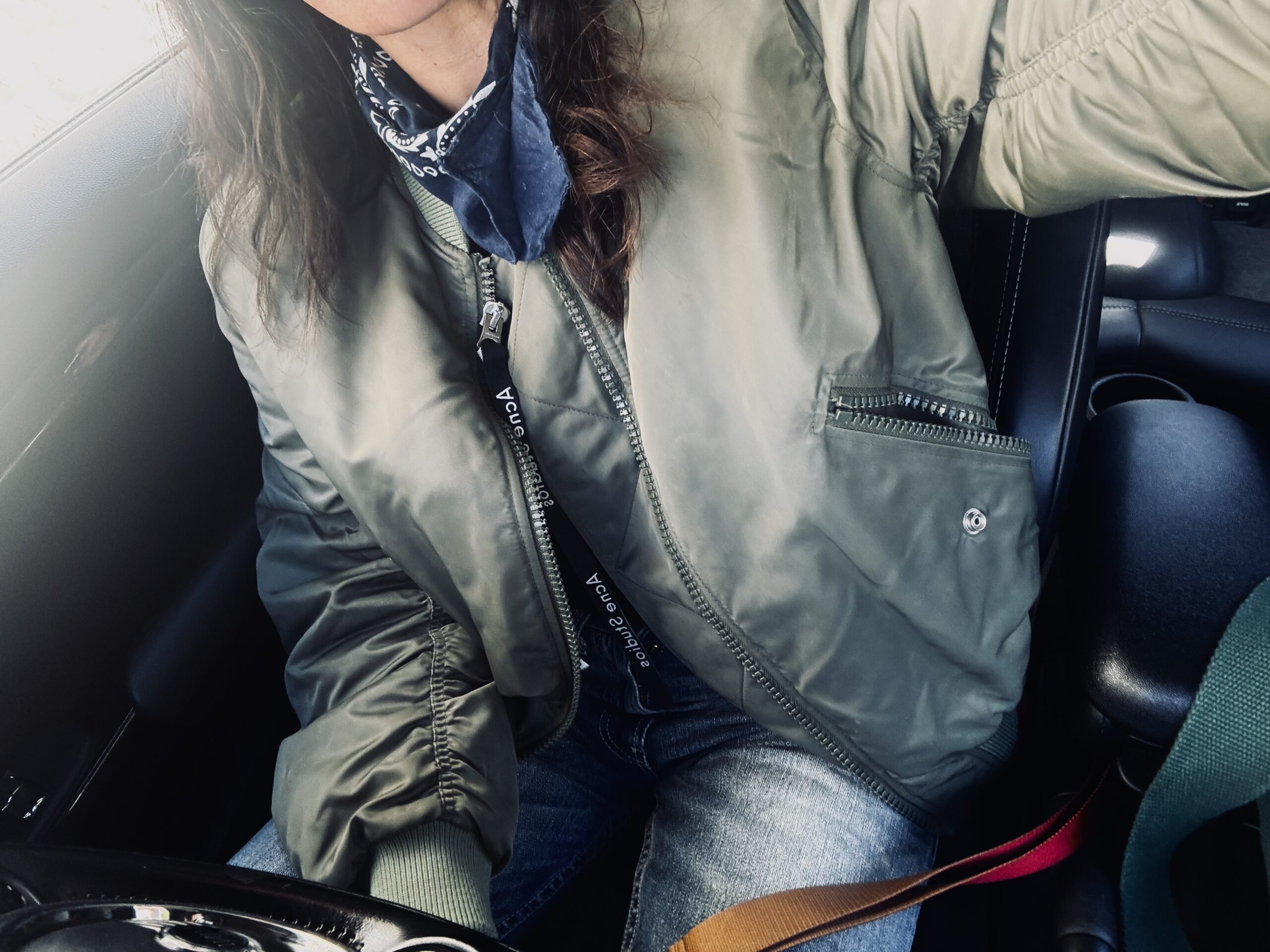 Tamara Chaudesaigues wearing a khaki Acne Studios bomber jacket with jeans