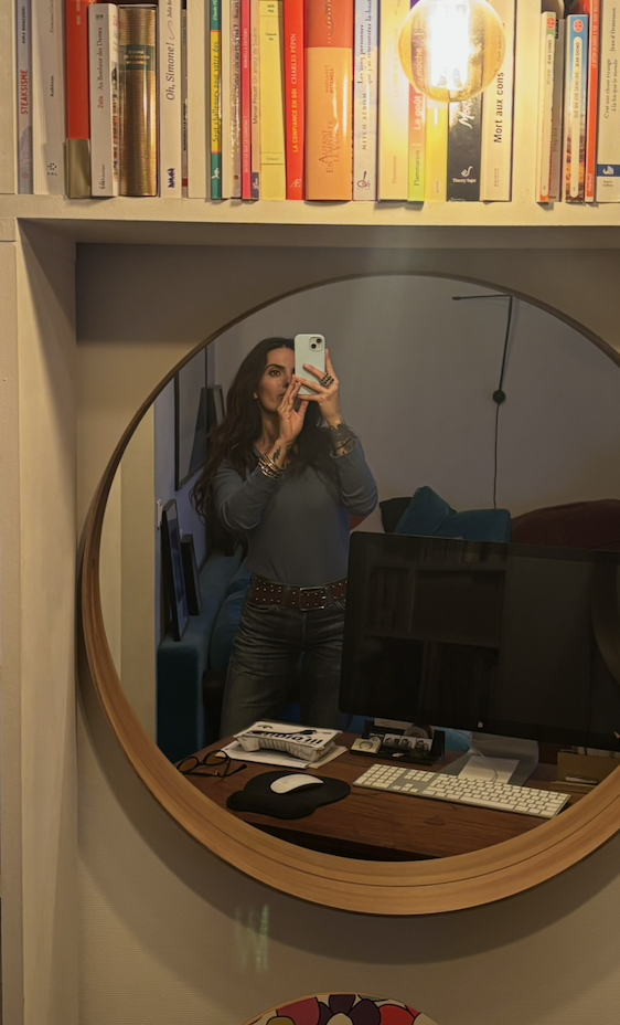Tamara Chaudesaigues beside her workspace and collection of design books
