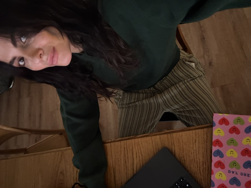 Tamara Chaudesaigues wearing a dark green jumper and striped trousers for an autumn outfit