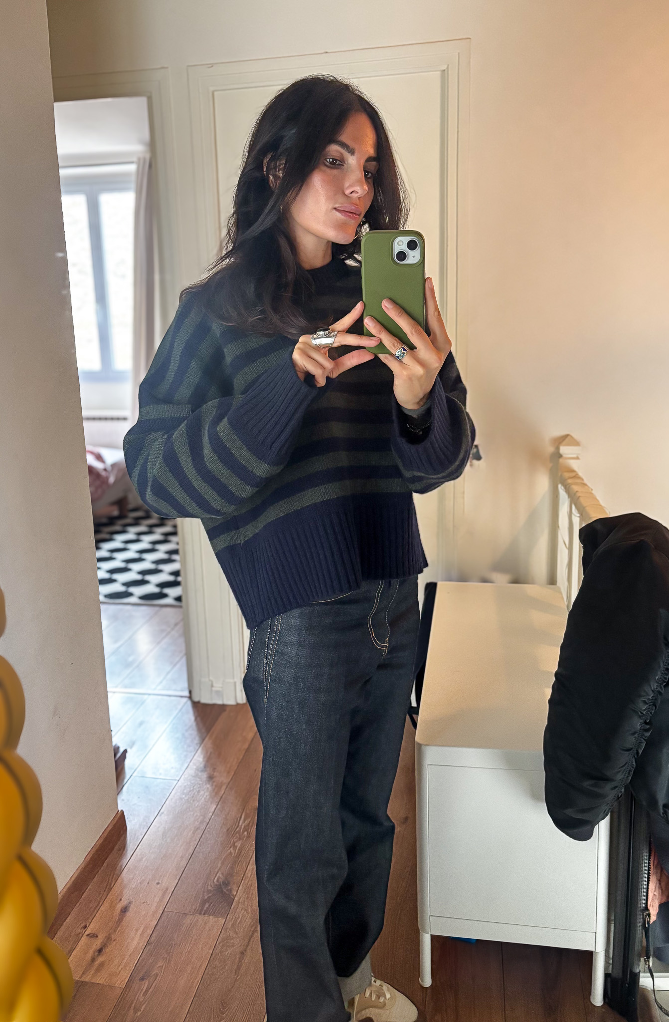Tamara Chaudesaigues wears a striped women's sweater from Skall Studio with Saint Laurent jeans and Nike Air Max 1 Crepe Hemp sneakers.